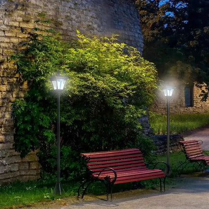 Red wooden bench with black wrought iron legs and armrests next to outsunny black dimmable led solar garden post lamps