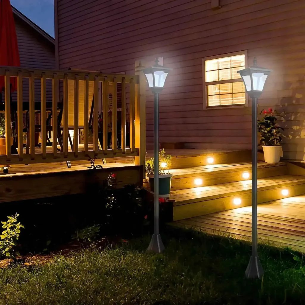 Outsunny set of 2 silver solar garden post lamps with dimmable leds illuminating a wooden deck and steps