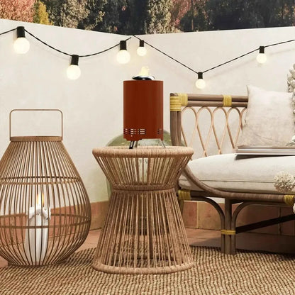 Rust-colored outsunny smokeless stainless steel cylindrical outdoor fire pit with flame on woven rattan side table