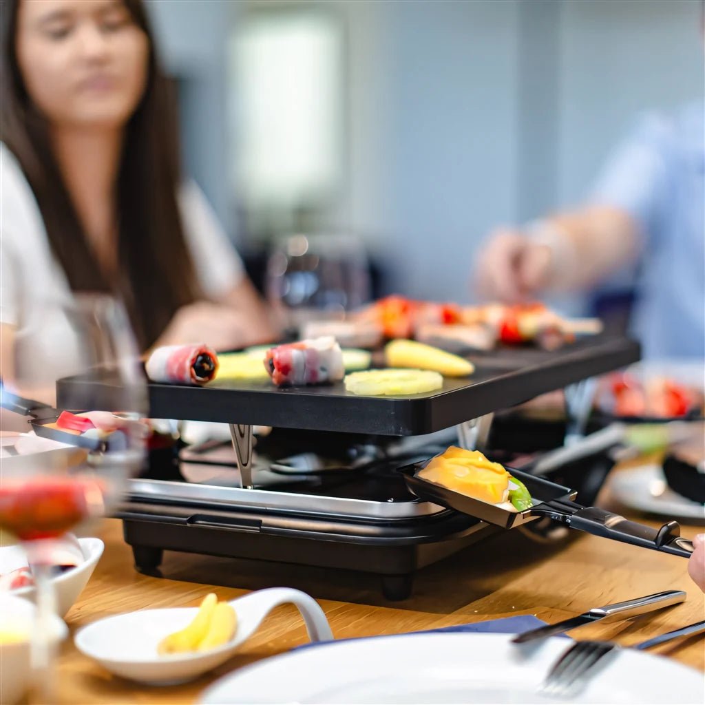 Black steba rc28 premium electric cast raclette grill with multiple cooking surfaces for sharing food