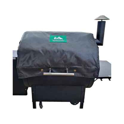 Black fabric thermal blanket for GMG pellet grills with green logo patch and metallic handle for grill protection